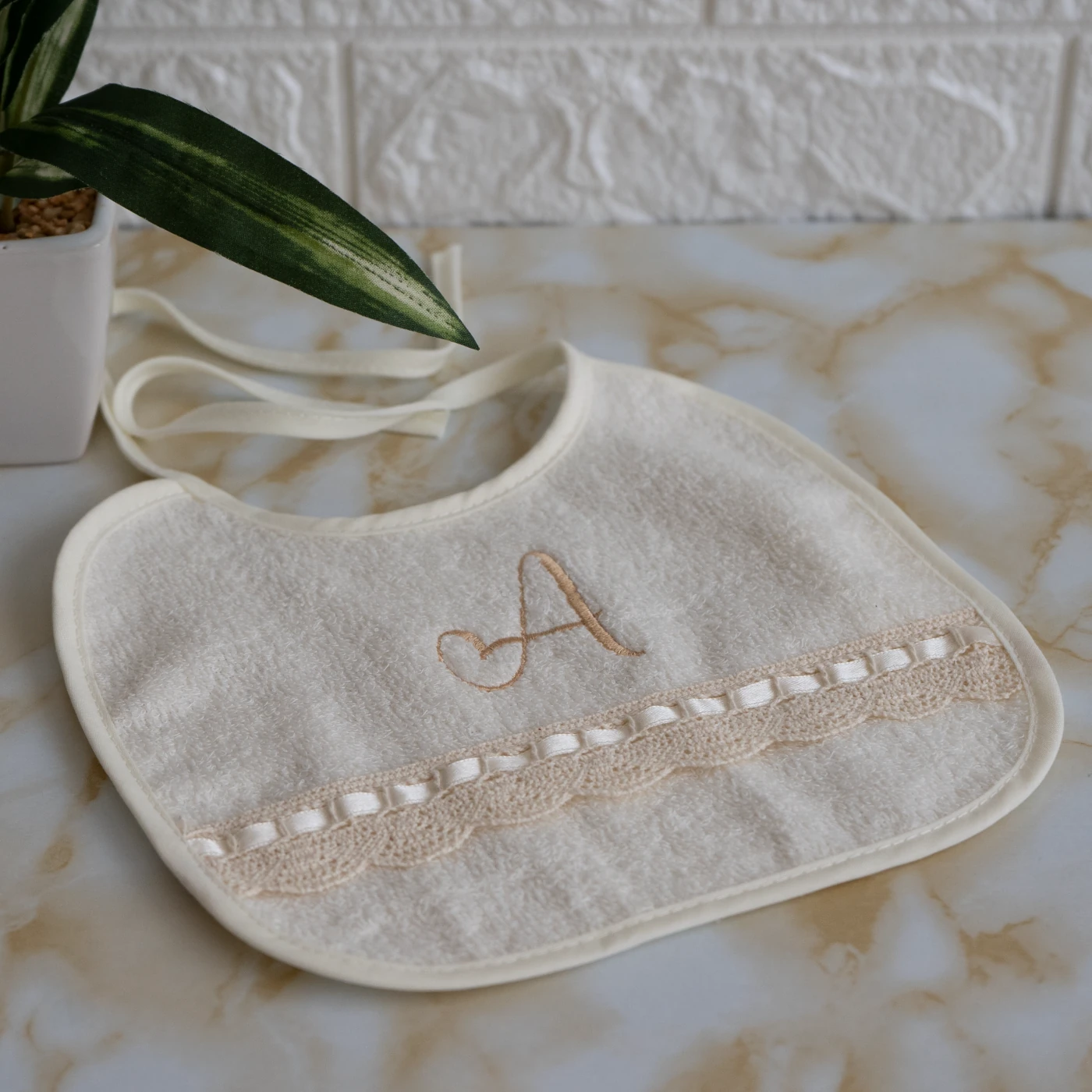 babero inicial bordado beige